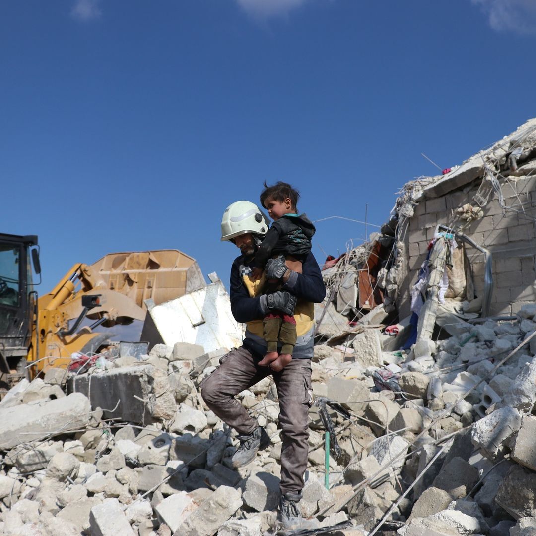 White helmet rescuing a child from the rubble