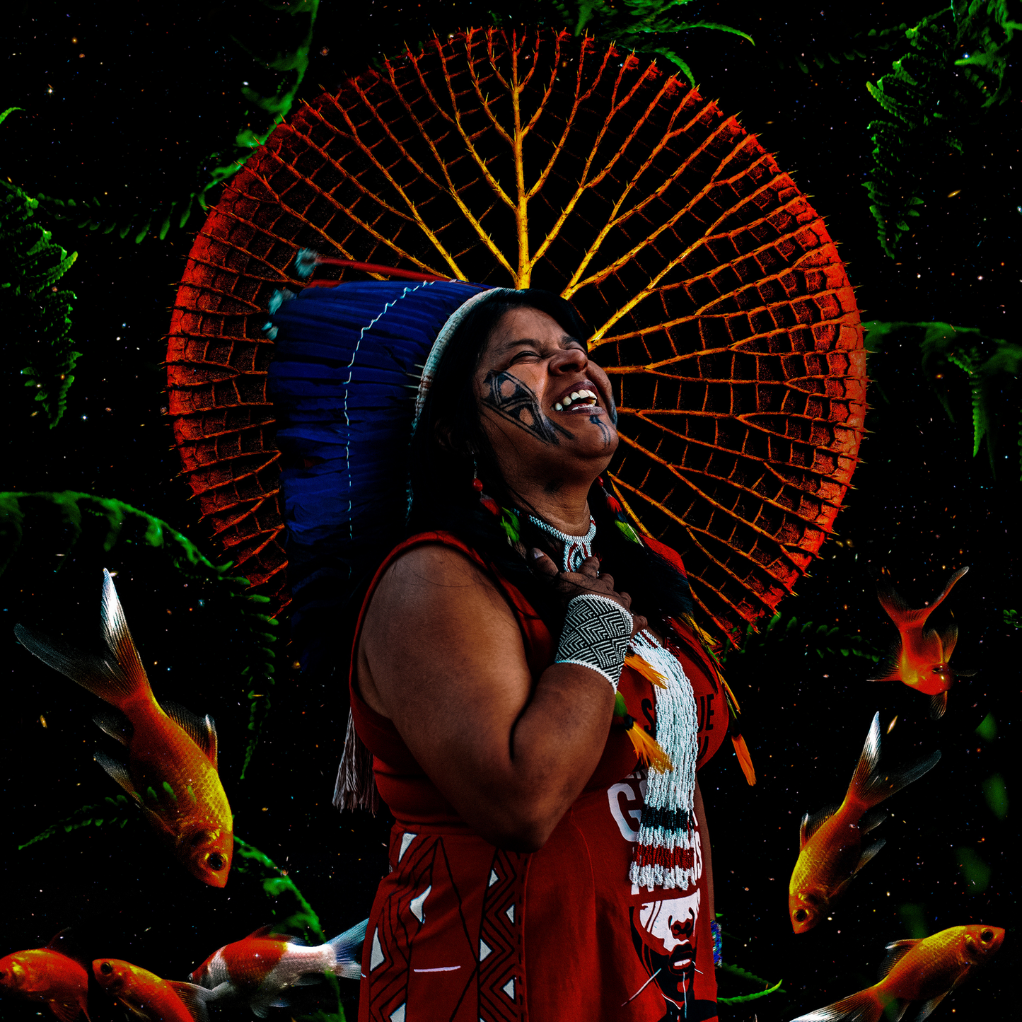 This is an image that shows an Indigenous Brazilian woman dressed in a traditional dress and headdress, facing up and smiling. In the background there are large wild leaves and a few fish towards the bottom.